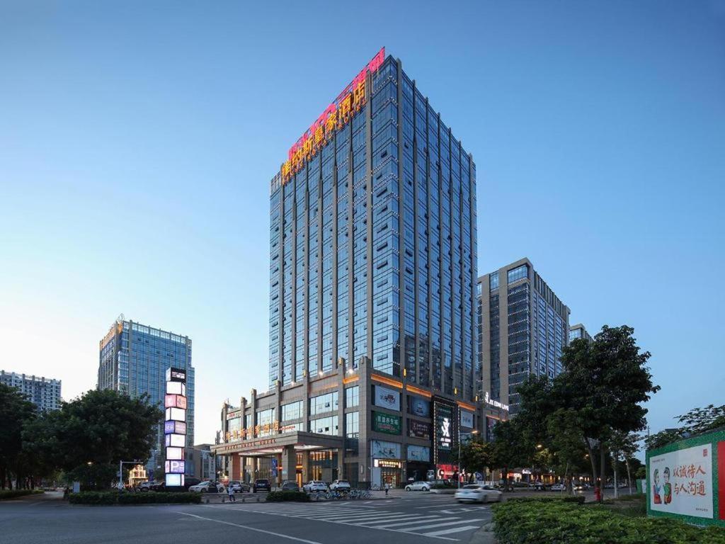 un edificio alto con un cartel en la parte superior en Venus Royal Hotel Guangxi Wuzhou Sanqicheng Meiguihu Park, en Wuzhou