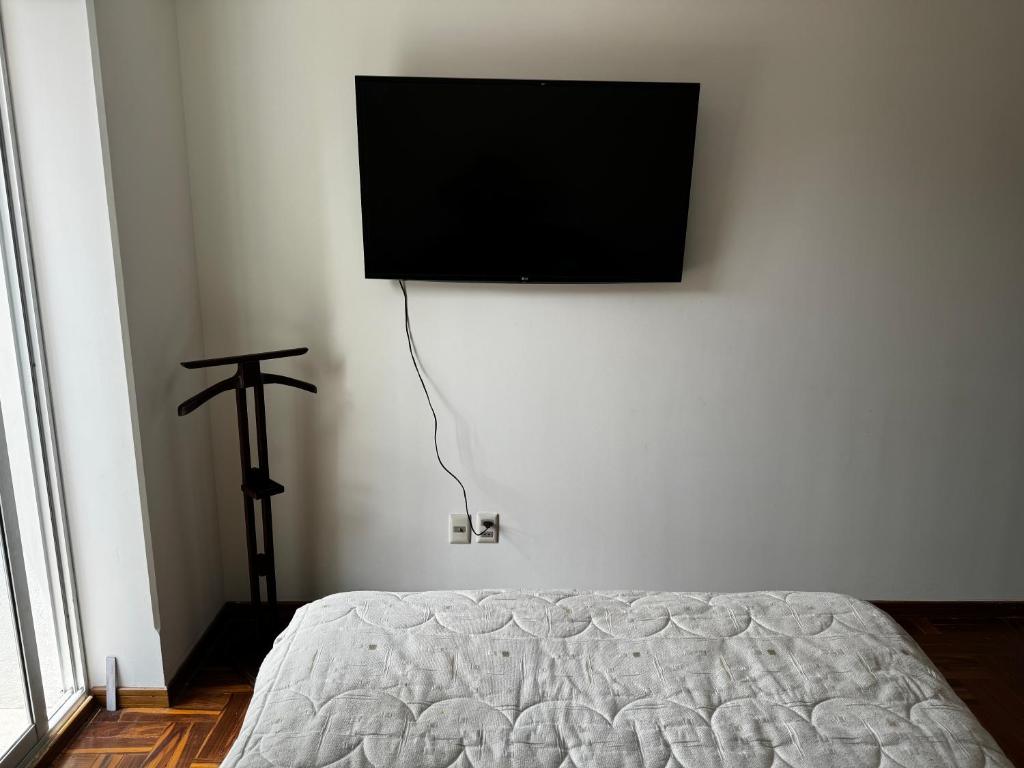 Schlafzimmer mit einem Bett und einem Flachbild-TV an der Wand in der Unterkunft Smart Room in La Paz