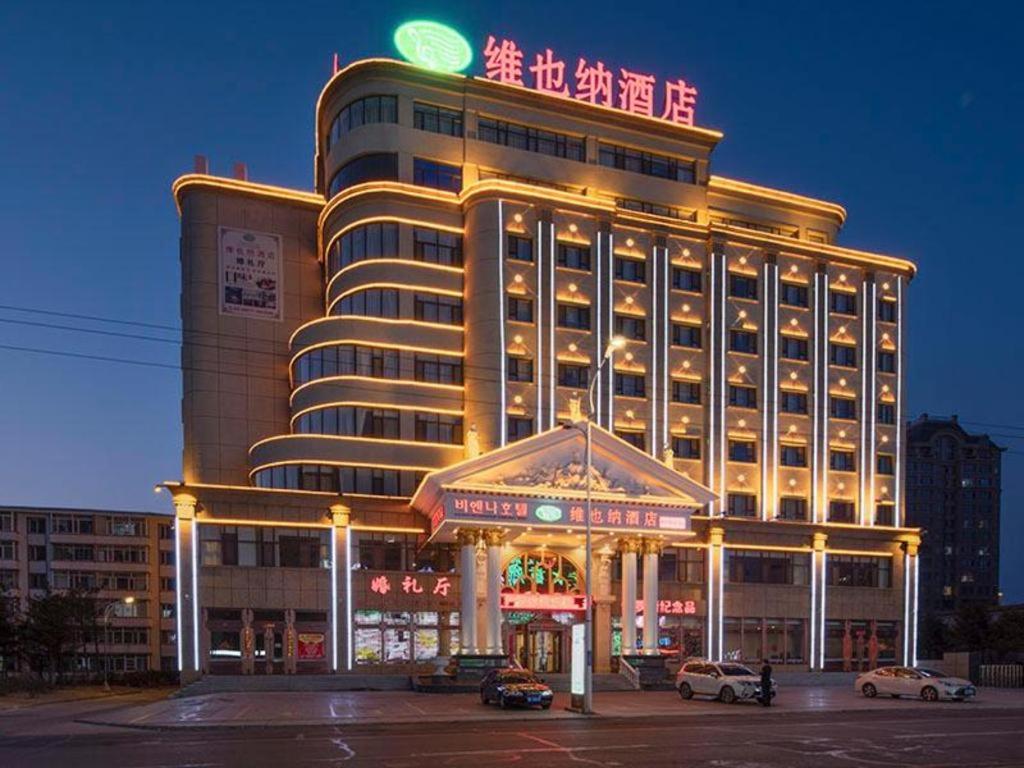 un edificio de hotel con un cartel encima en Vienna Hotel Jilin Huichun Yadu Huayuan en Hunchun