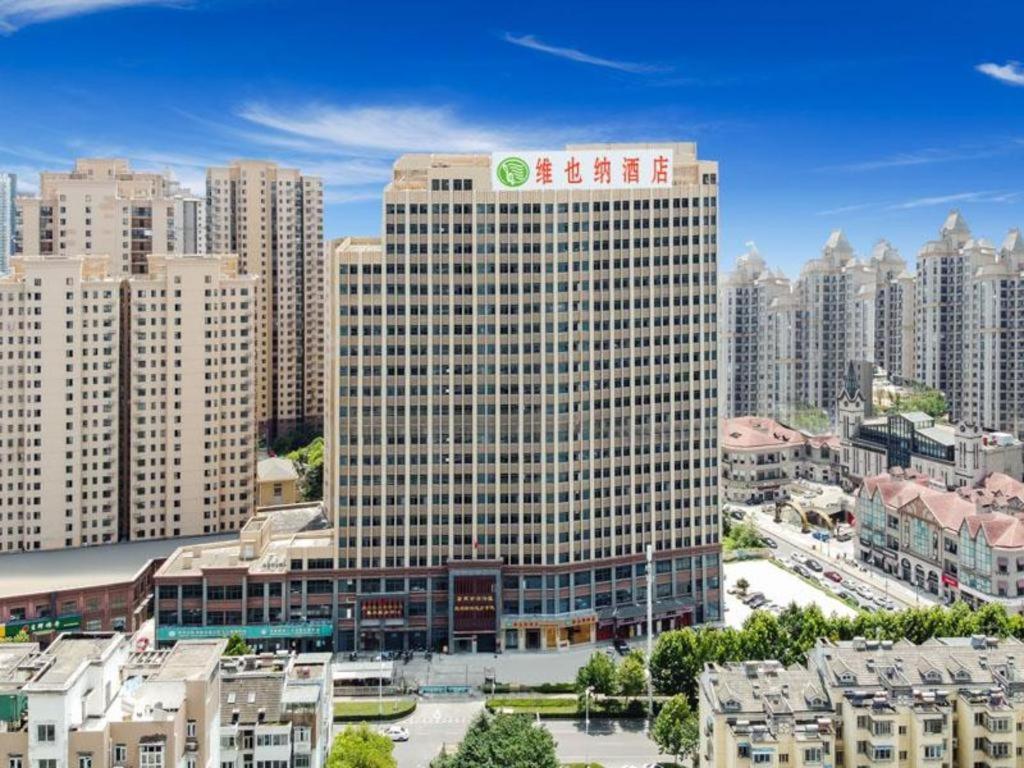 合肥市にあるVienna Hotel Hefei Railway Station Yuanyi Times Plazaの市の看板が貼られた高層ビル