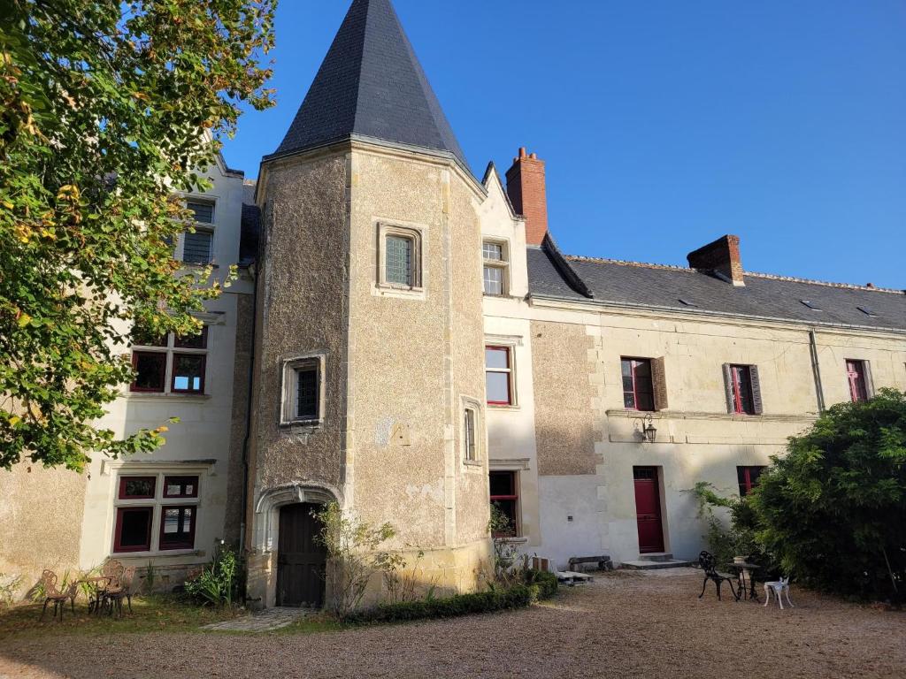 un antiguo edificio con una torre a un lado. en Castel Saint Laurent en Langeais