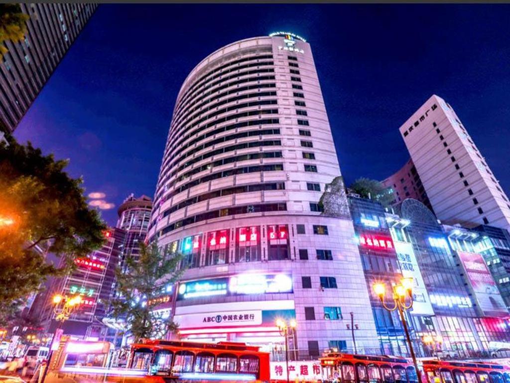 un edificio alto con luces rojas y azules. en Vienna Hotel Chongqing Jiefangbei Hongyadong, en Chongqing