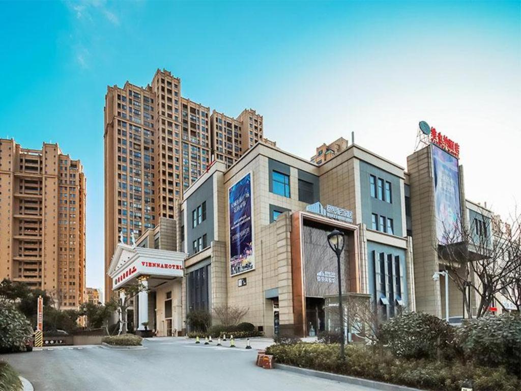 ein Gebäude in einer Stadt mit hohen Gebäuden in der Unterkunft Vienna Hotel Jiangsu Suzhou Wujiang Bus Passenger Station in Hubin