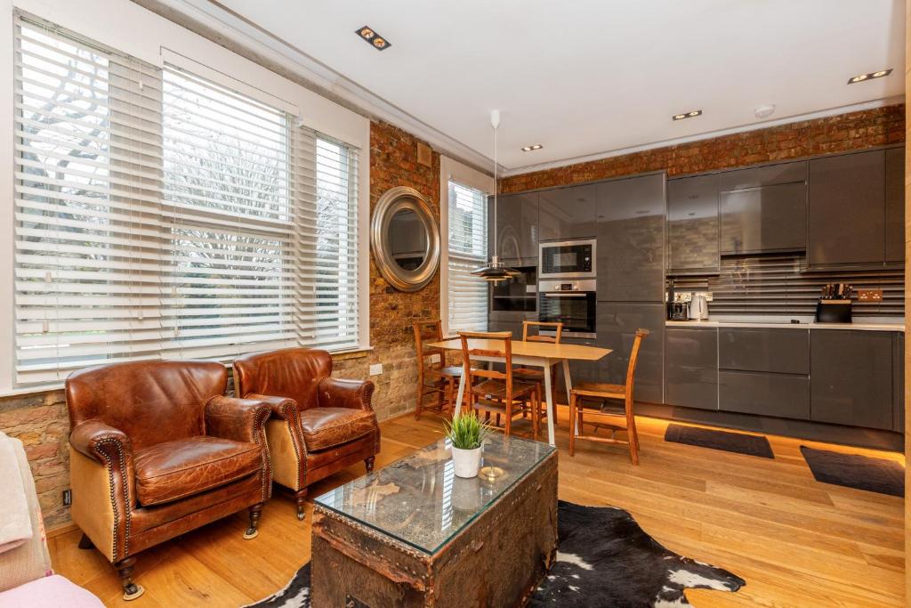 a living room with leather chairs and a table at Luxury 1BR, 2 min Putney Train St, 5 min to Tube in London