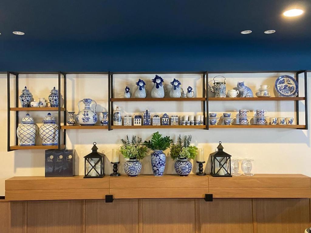 a shelf filled with blue and white vases at Eat Sleep Chann in Chanthaburi