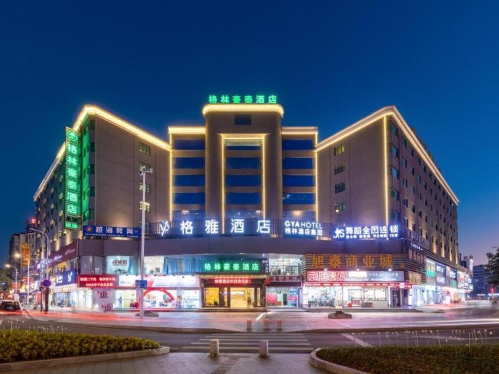 un gran edificio con luces verdes y blancas. en Gya Hotel Zhuhai International Airport New Town en Baigaonongchang