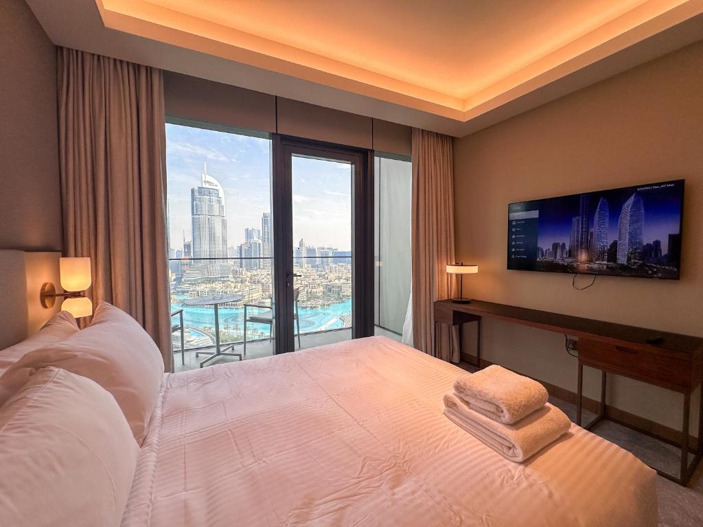 a bedroom with a large bed and a large window at Luxury 3-bedroom apartment with a stunning view of the Burj Khalifa and the Fountain in Dubai