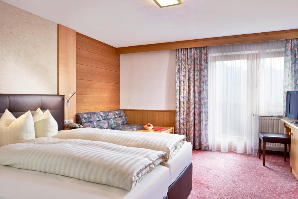 Ένα ή περισσότερα κρεβάτια σε δωμάτιο στο Hotel Tirol Fiss 4Sterne Superior