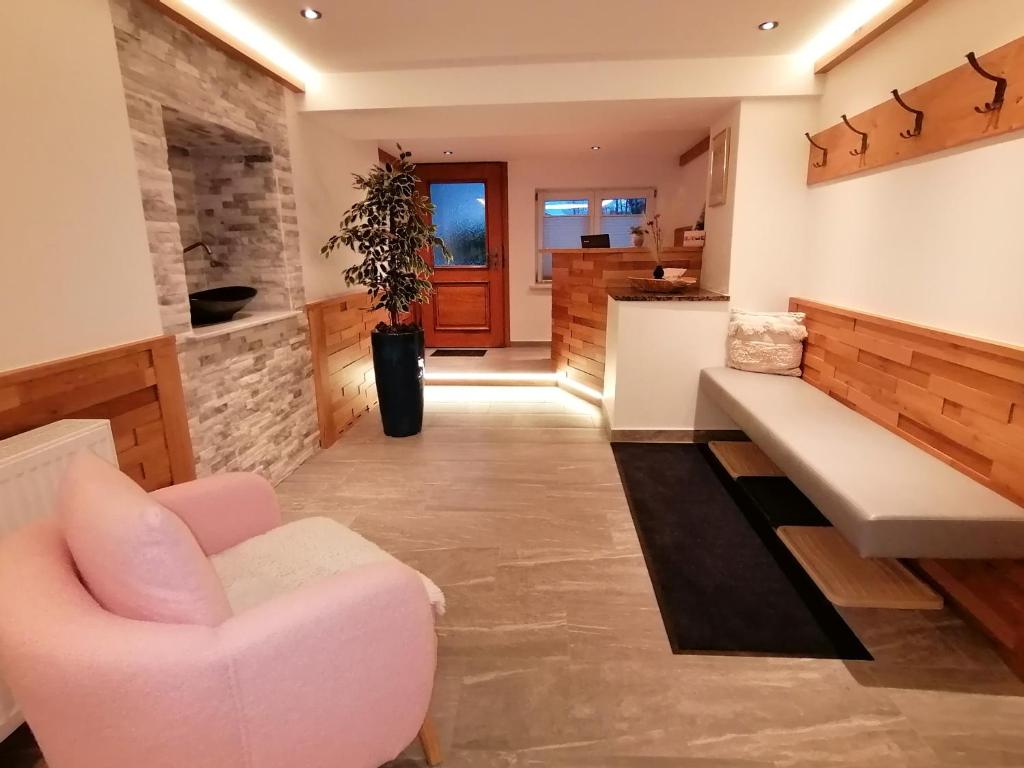 sala de estar con sofá rosa y silla en Pension Heilbad Burgwies, en Stuhlfelden