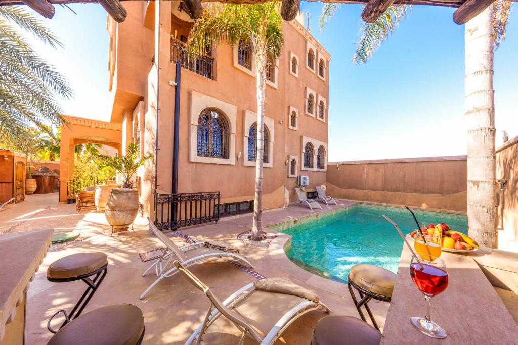 マラケシュにあるRiad Ushuaia La Villa - Centre Marrakechのスイミングプール(テーブル、椅子付)が備わるヴィラです。