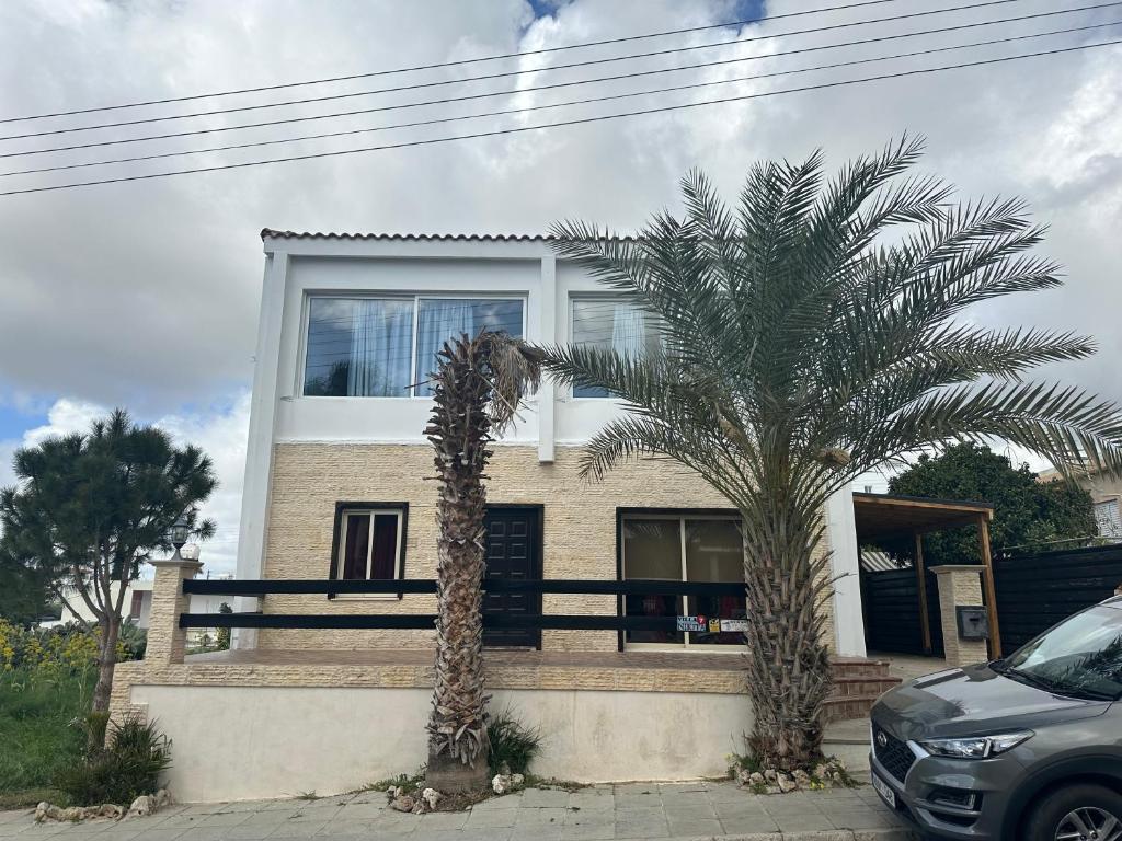 a house with two palm trees in front of it at Villa Nikitas in Konia