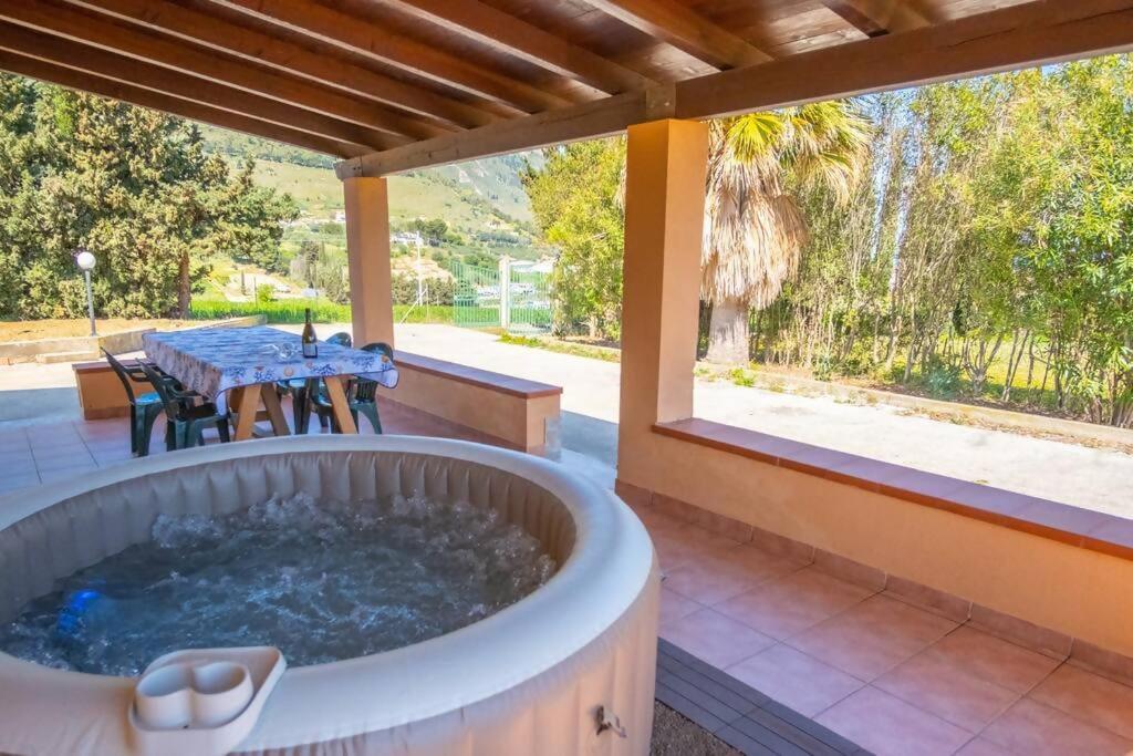 a hot tub on a patio with a table at Villa Indipendente Jacuzzi Giardino Clima WiFi in Castellammare del Golfo