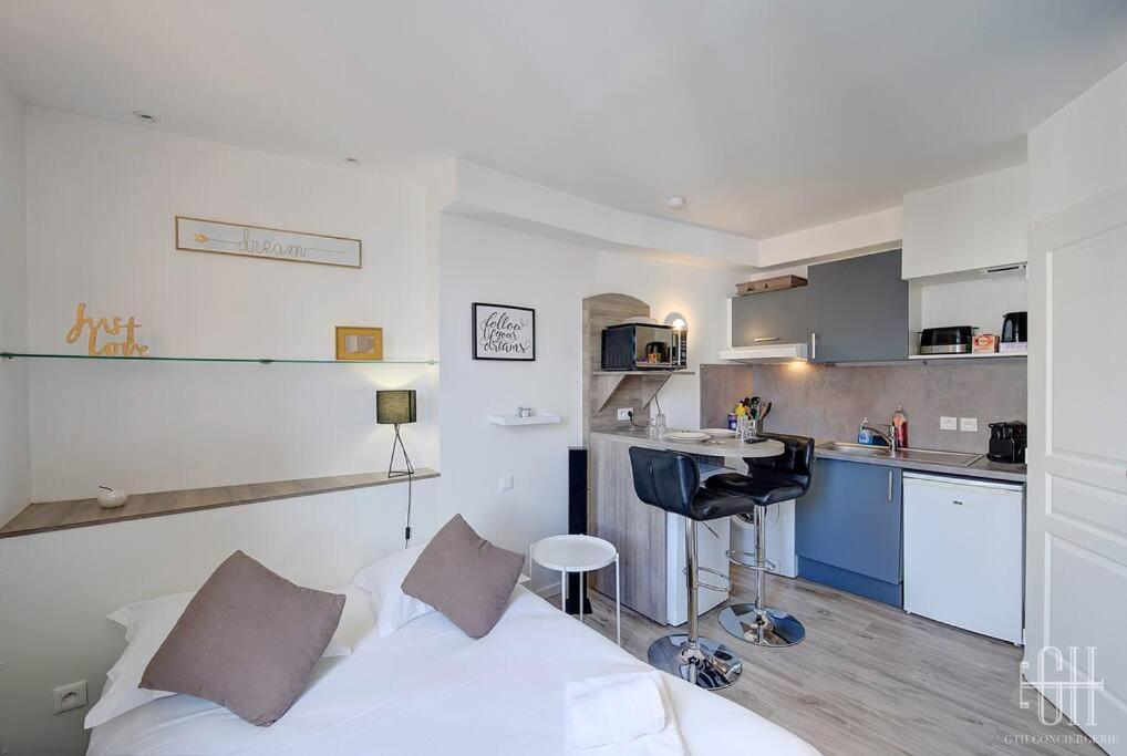 Cet appartement comprend une chambre avec un lit blanc et une cuisine. dans l'établissement Le Traversière 5 / Proche Gare, à Tours
