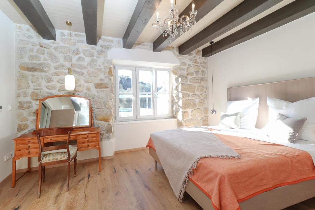 een slaapkamer met een bed, een spiegel en een bureau bij Deluxe Nature Resort Galovi Dvori in Rab