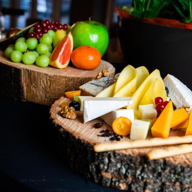 a display of fruits and vegetables on two wooden cutting boards at The Hotel Unforgettable - Hotel Tiliana by Homoky Hotels & Spa in Budapest