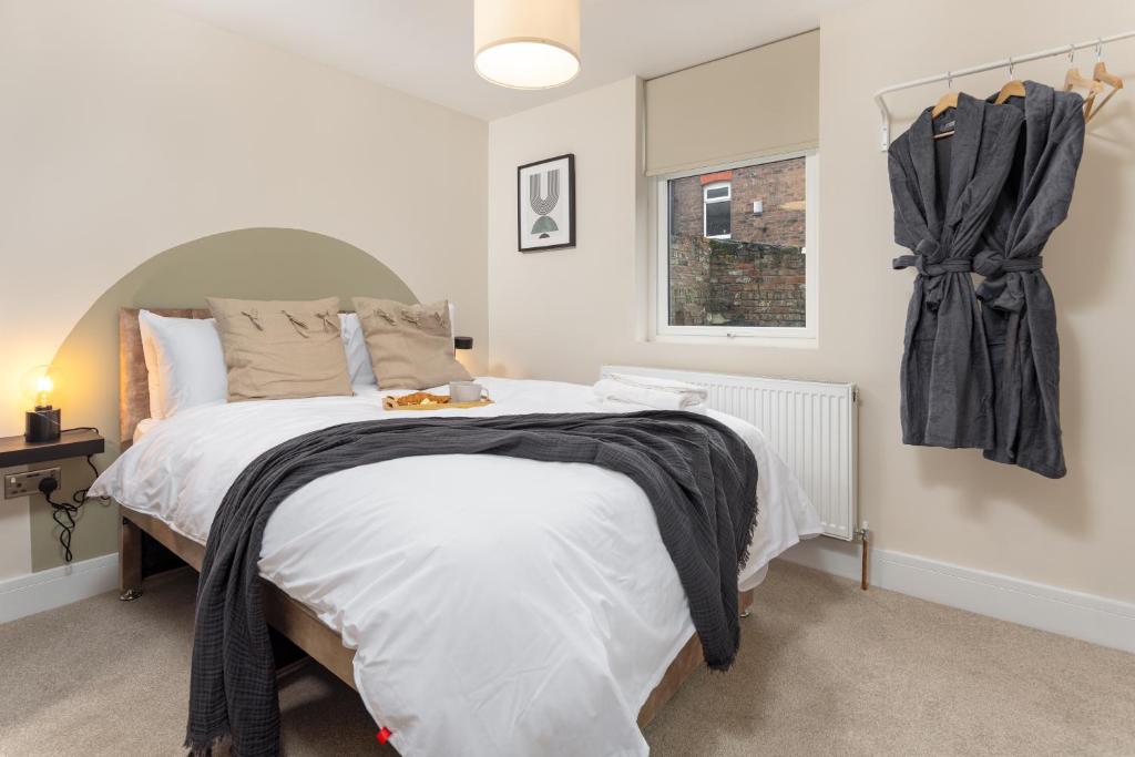 um quarto com uma cama com lençóis brancos e uma janela em Broughton Place: Contemporary Apartments in Liverpool em Liverpool