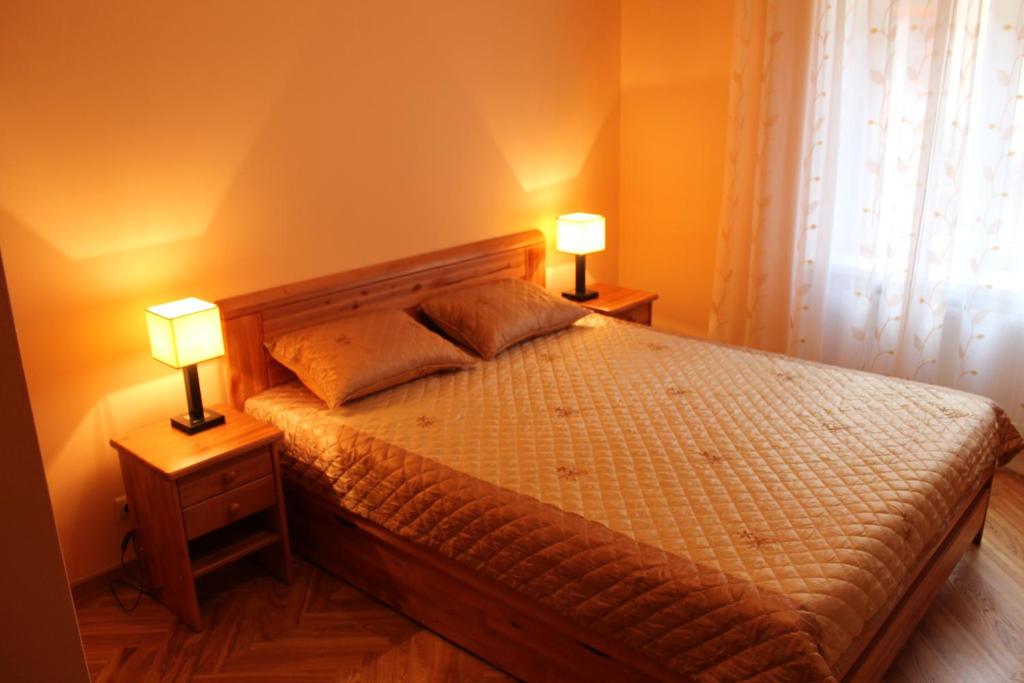 ein Schlafzimmer mit einem Bett und zwei Lampen an Tischen in der Unterkunft Old Riga Apartment in Riga