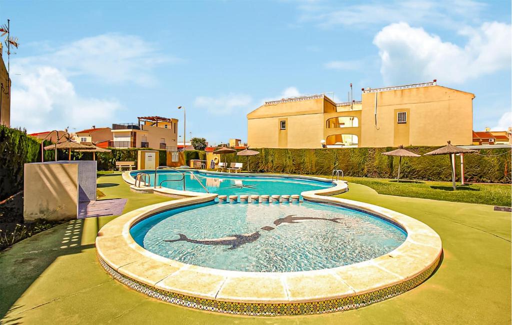 a large swimming pool in a yard with a building at Urb, La Siesta in Torrevieja