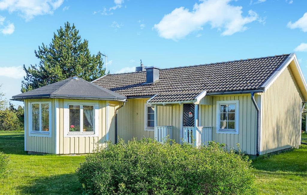 a small yellow house on a green lawn at Beautiful Home In Borgholm With 2 Bedrooms in Föra