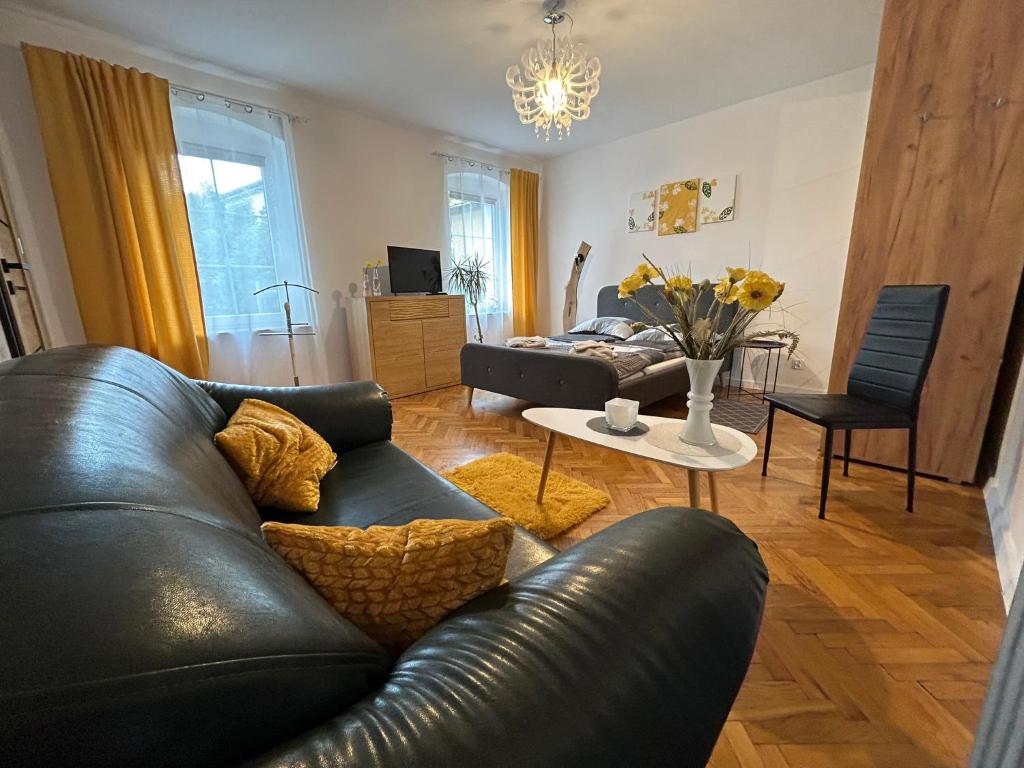 a living room with a black leather couch and a table at ARTHOME in Wrocław