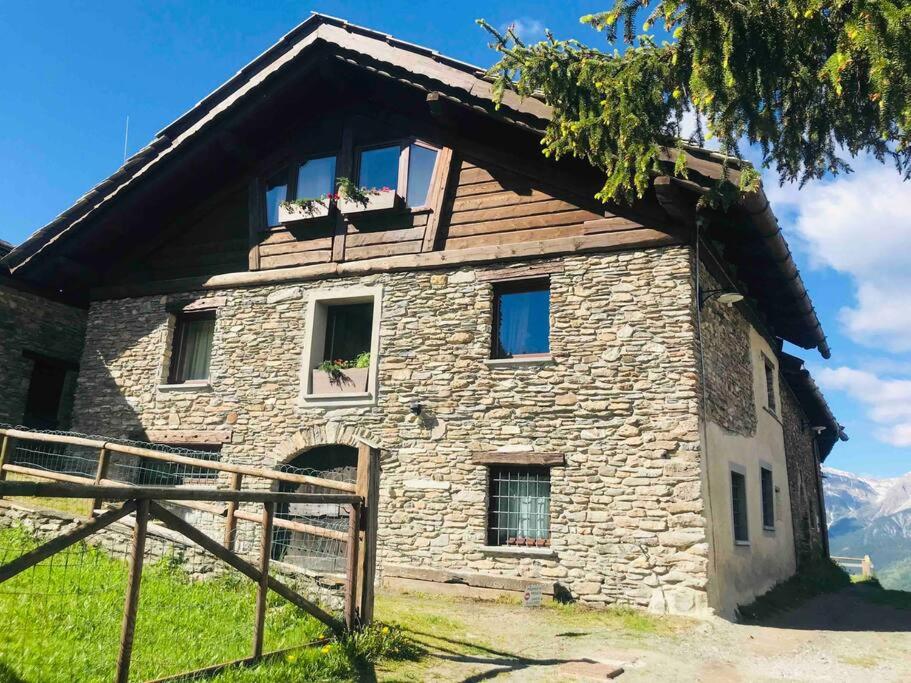 ein Steinhaus mit Fenstern auf einem Berg in der Unterkunft Baita Gran Bosco: appartamento per 6 persone in Monfol