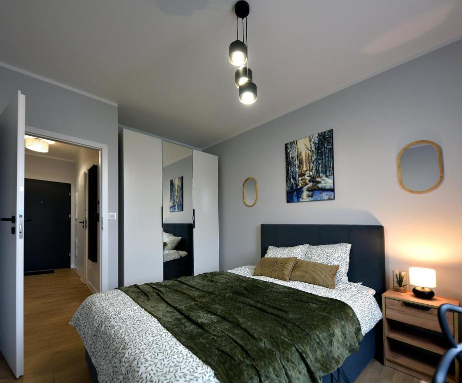 a bedroom with a large bed with a blue headboard at SuperApart Prymasa 1000-lecia 6a, Hidden Gem - Ideal for Relaxation & Escapes in Rzeszów