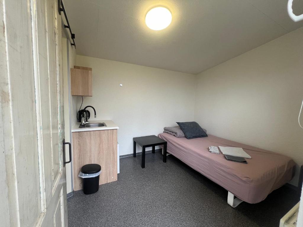 ein kleines Schlafzimmer mit einem Bett und einem Tisch in der Unterkunft Klokkehøj in Ullerslev