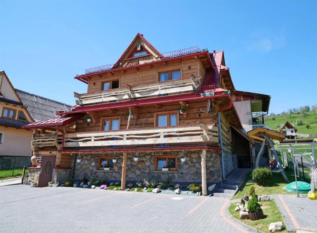 a large wooden house in the middle of a street at Willa u Perełki in Zakopane