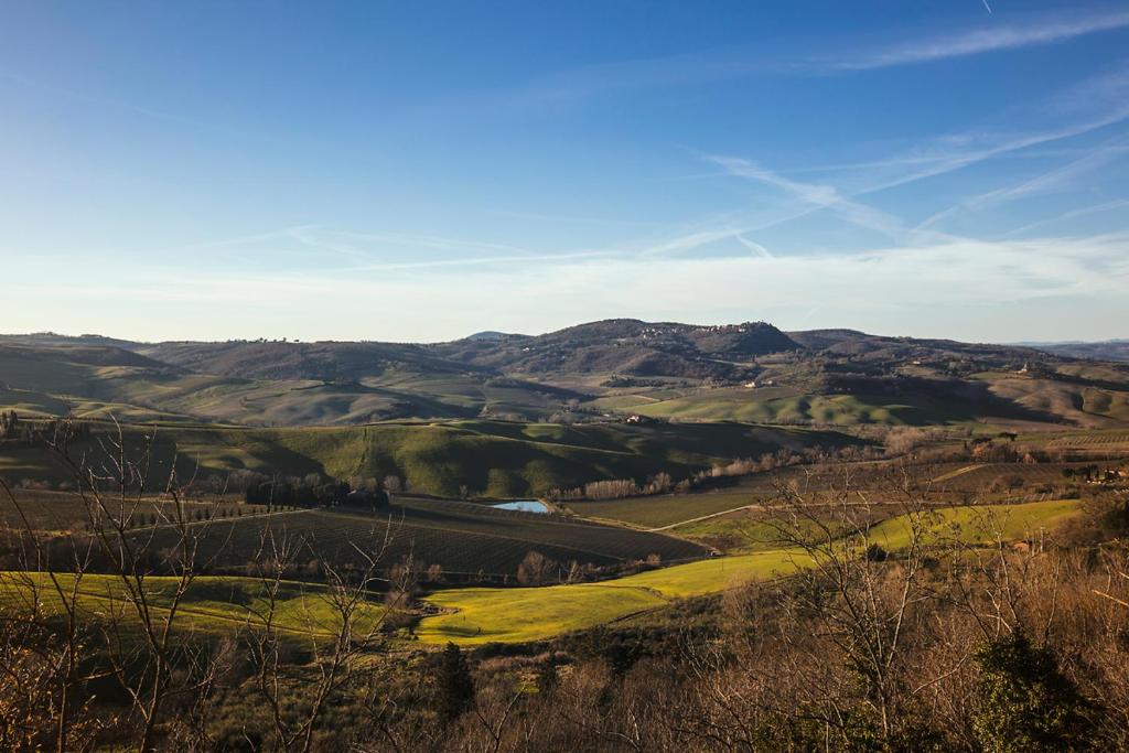 uitzicht op een vallei met bergen op de achtergrond bij CASALE LE CIVETTE in Montepulciano