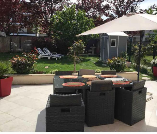 un patio avec une table, des chaises et un parasol dans l'établissement Maison à 10 min à pieds du RER Bourg la reine, à Bourg-la-Reine
