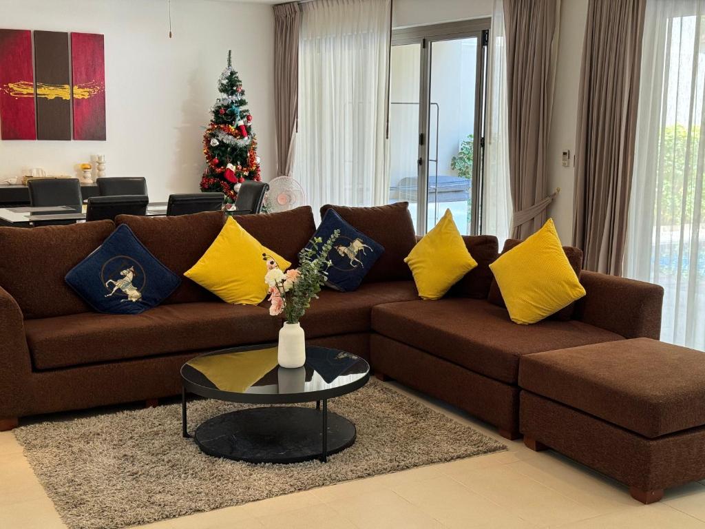 a living room with a brown couch and a christmas tree at Wonderful villa Harmony BangTao beach in Bang Tao Beach
