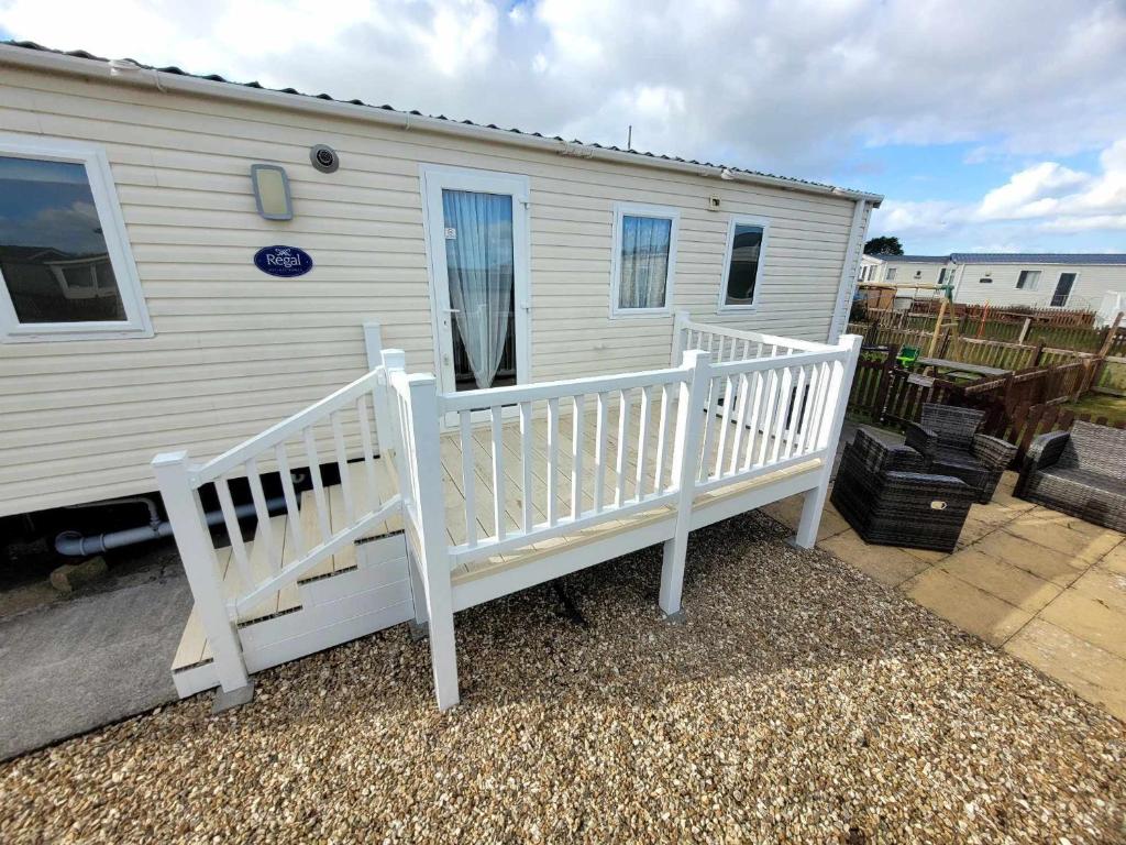 a white house with a porch and a white rail at 163 Holiday Resort Unity Brean - Centrally Located Pet Stays Free - Passes Included No Workers sorry in Brean
