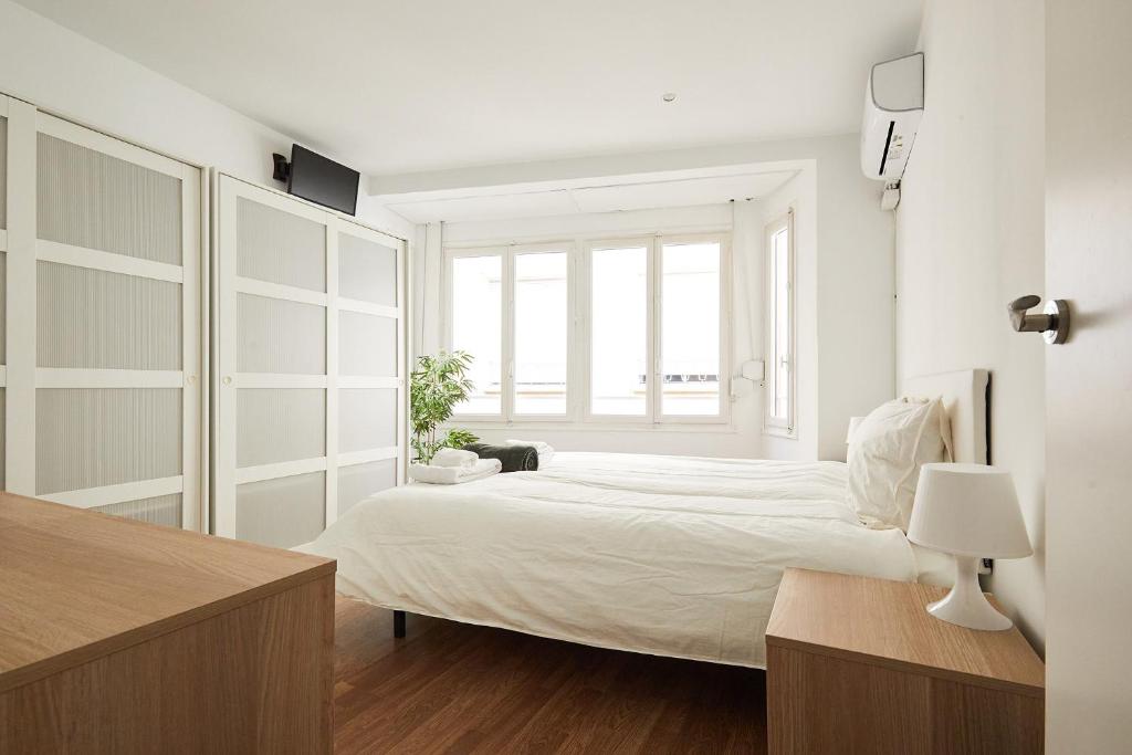 a white bedroom with a bed and a window at Low Cost Apartments Center Elche in Elche