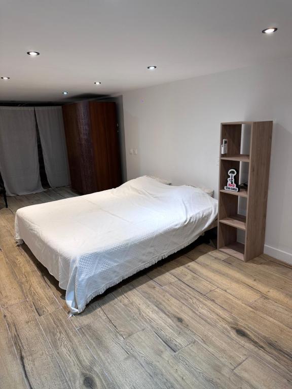 a bedroom with a white bed and a wooden floor at Casa Mare, CABANON SUR LA PLAGE à Ajaccio vue sanguinaires in Ajaccio