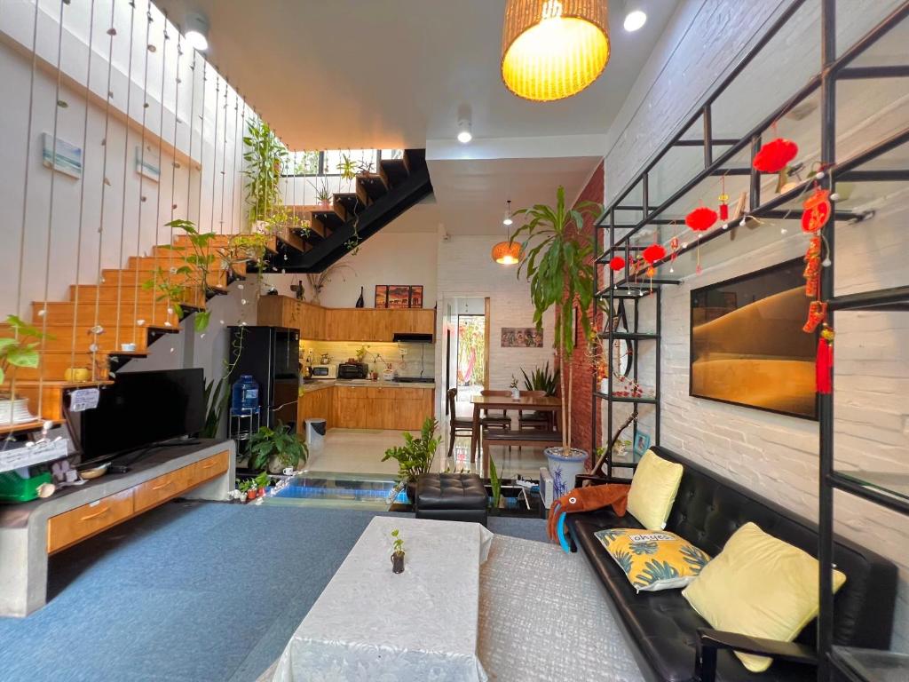 ein Wohnzimmer mit einem Sofa und einer Treppe in der Unterkunft Nguyễn Villa Royale in La Gi