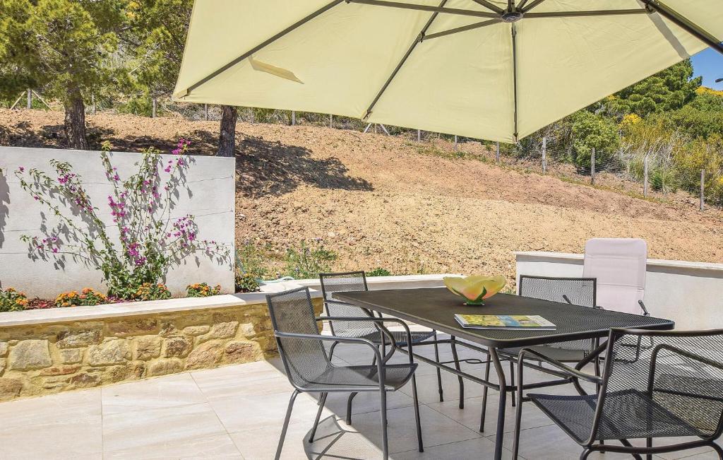 a table and chairs with an umbrella on a patio at Cozy Apartment In Ogliastro Marina in Montecorice