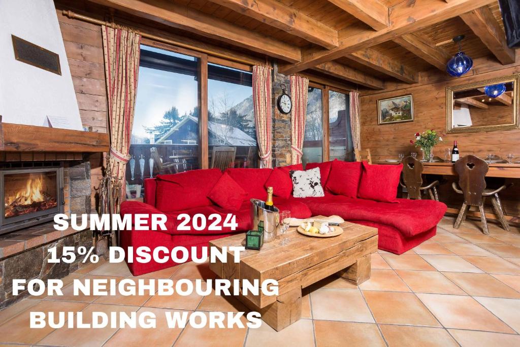 een woonkamer met een rode bank en een open haard bij Parc du Mont Blanc 12 appt - Chamonix All Year in Chamonix-Mont-Blanc