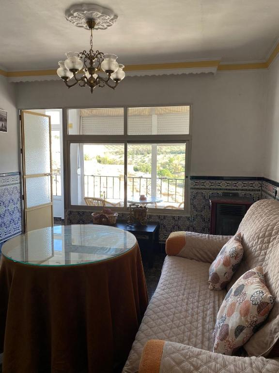 salon ze szklanym stołem i kanapą w obiekcie Casa Rural Balcones de Setenil w mieście Setenil