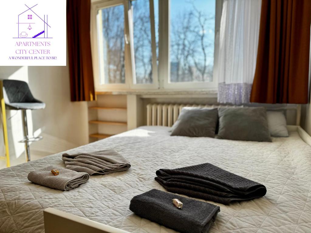 1 dormitorio con 1 cama con toallas y ventana en :: Apartment City Center ::, en Varsovia