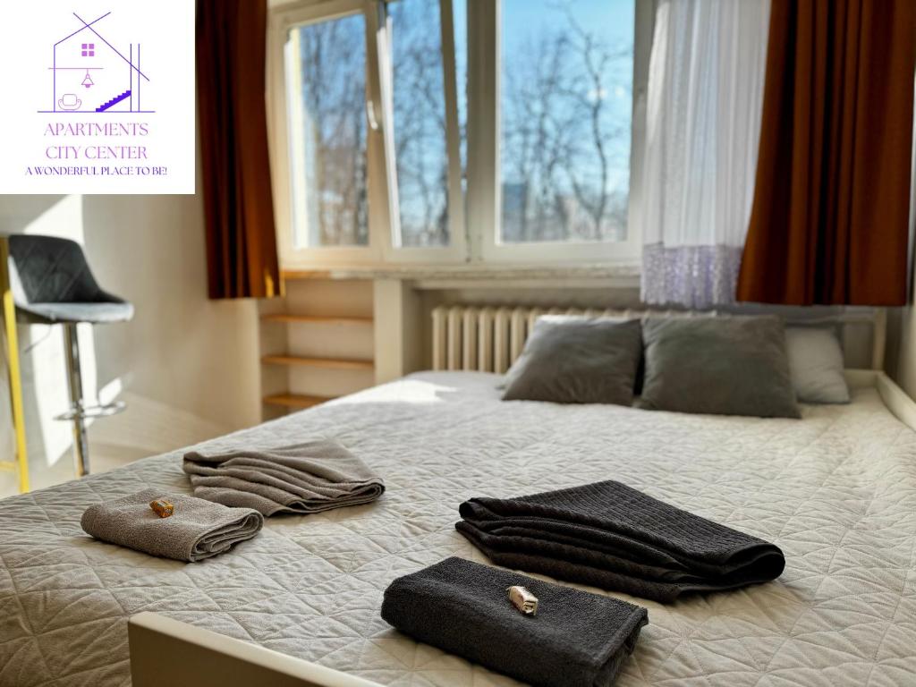 sypialnia z łóżkiem z ręcznikami i oknem w obiekcie :: Apartment City Center :: w Warszawie