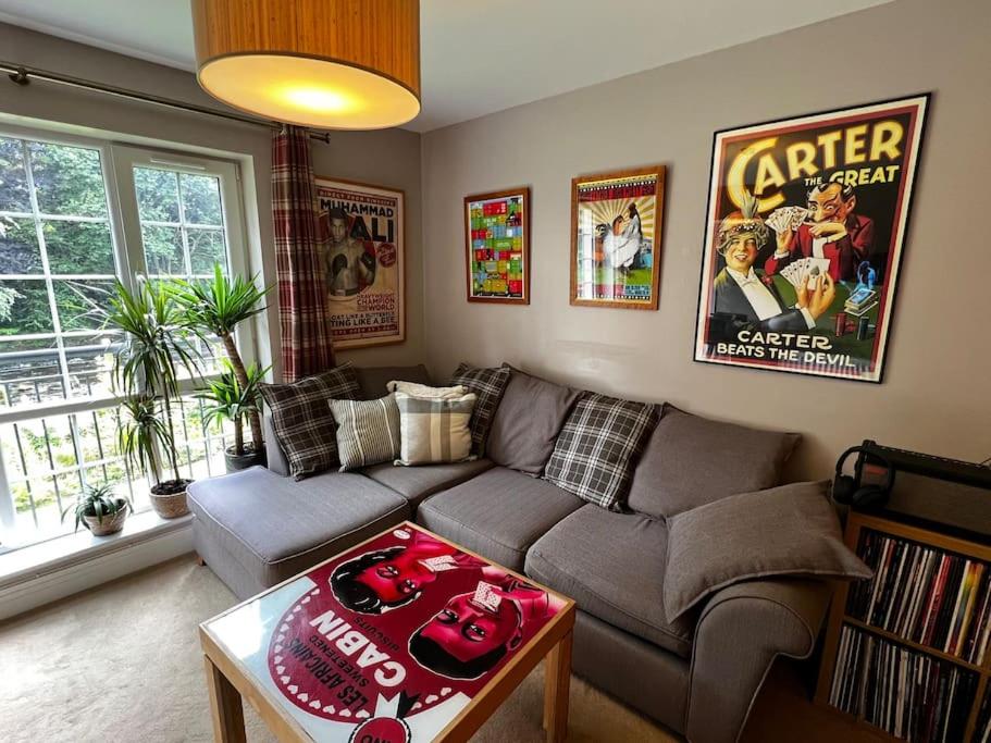 a living room with a couch and a table at Riverside one bedroom flat in Bridge of Allan