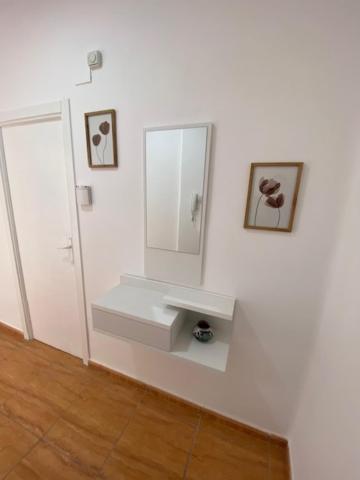 a bathroom with a sink and a mirror on a wall at Exclusivo Apartamento ALZIRA in Alzira