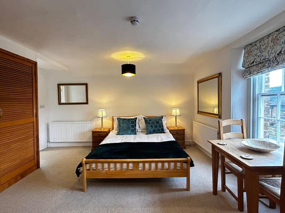 a bedroom with a bed with blue pillows and a table at Grouse in Lyddington