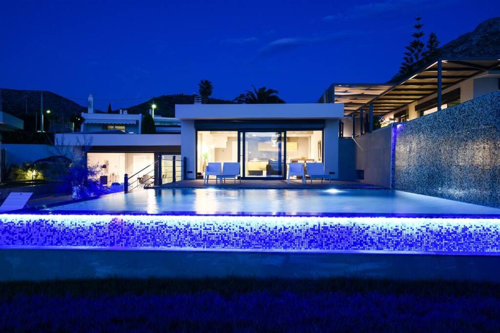 una villa con piscina di notte di Luxury Beachfront Villa Selenia Gold in Sounio a Sounio