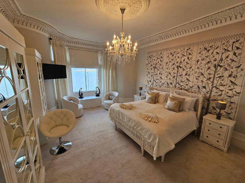 a bedroom with a large bed and a chandelier at Merchant's View - Luxury Seaside Designer Retreat in Rothesay