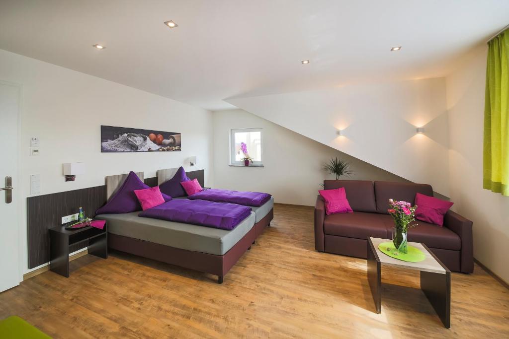 a living room with a couch and purple pillows at Hotel Stock Bäckerstüble in Friedrichshafen
