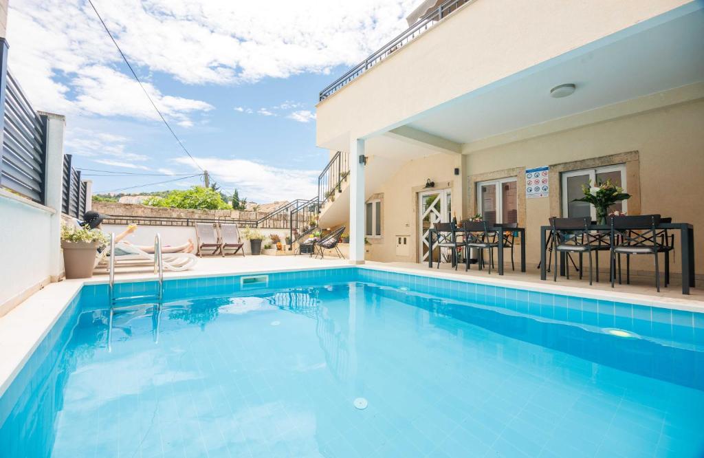 a swimming pool in front of a house at Apartments Gabrieri in Dubrovnik