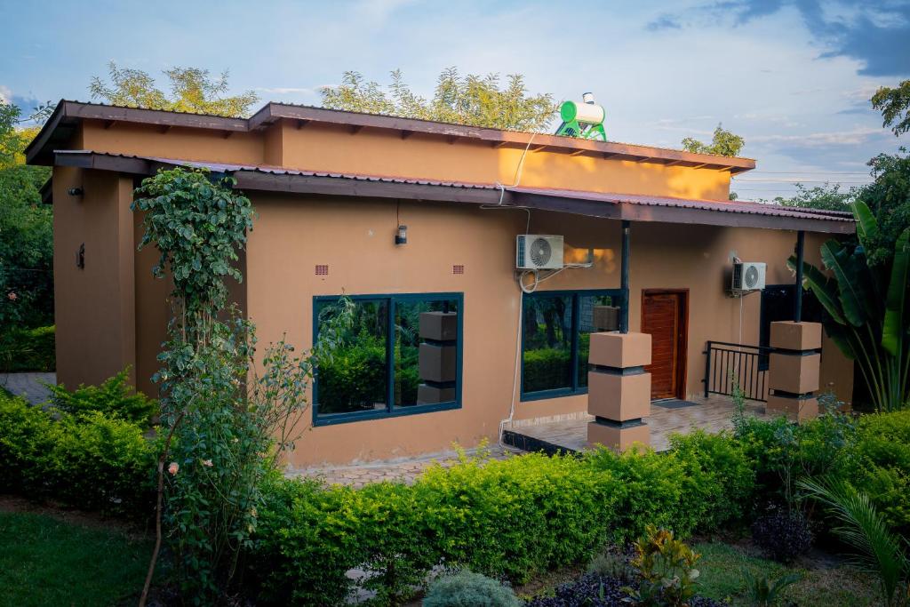a small house with a green statue on the roof at Kamps Apartment - Foxdale Forest in Lusaka