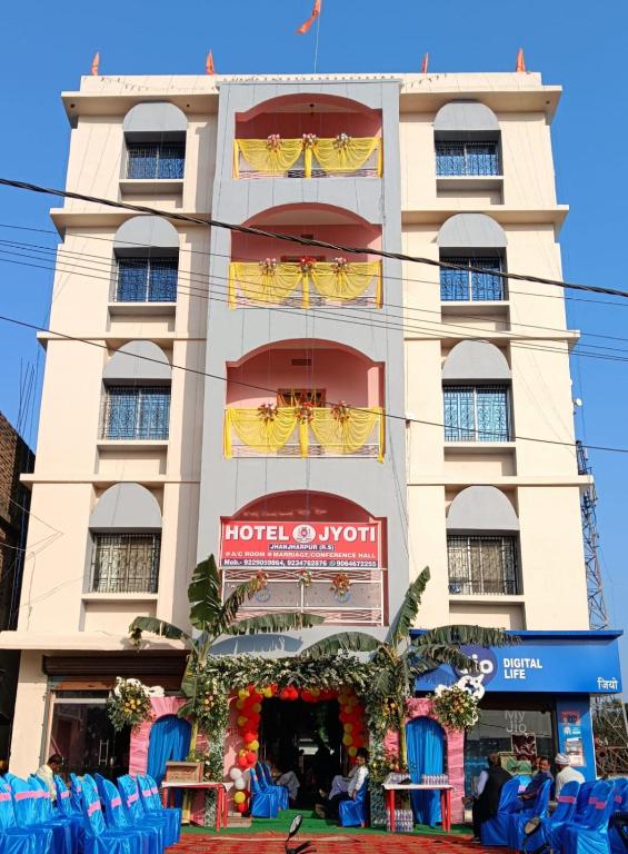 um edifício com cadeiras azuis em frente em Hotel Jyoti em Madhubani