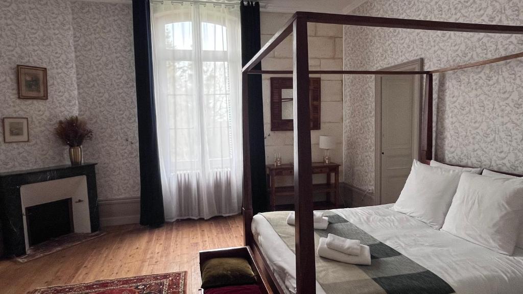 1 dormitorio con cama con dosel y chimenea en Domaine du Faure en Chadurie